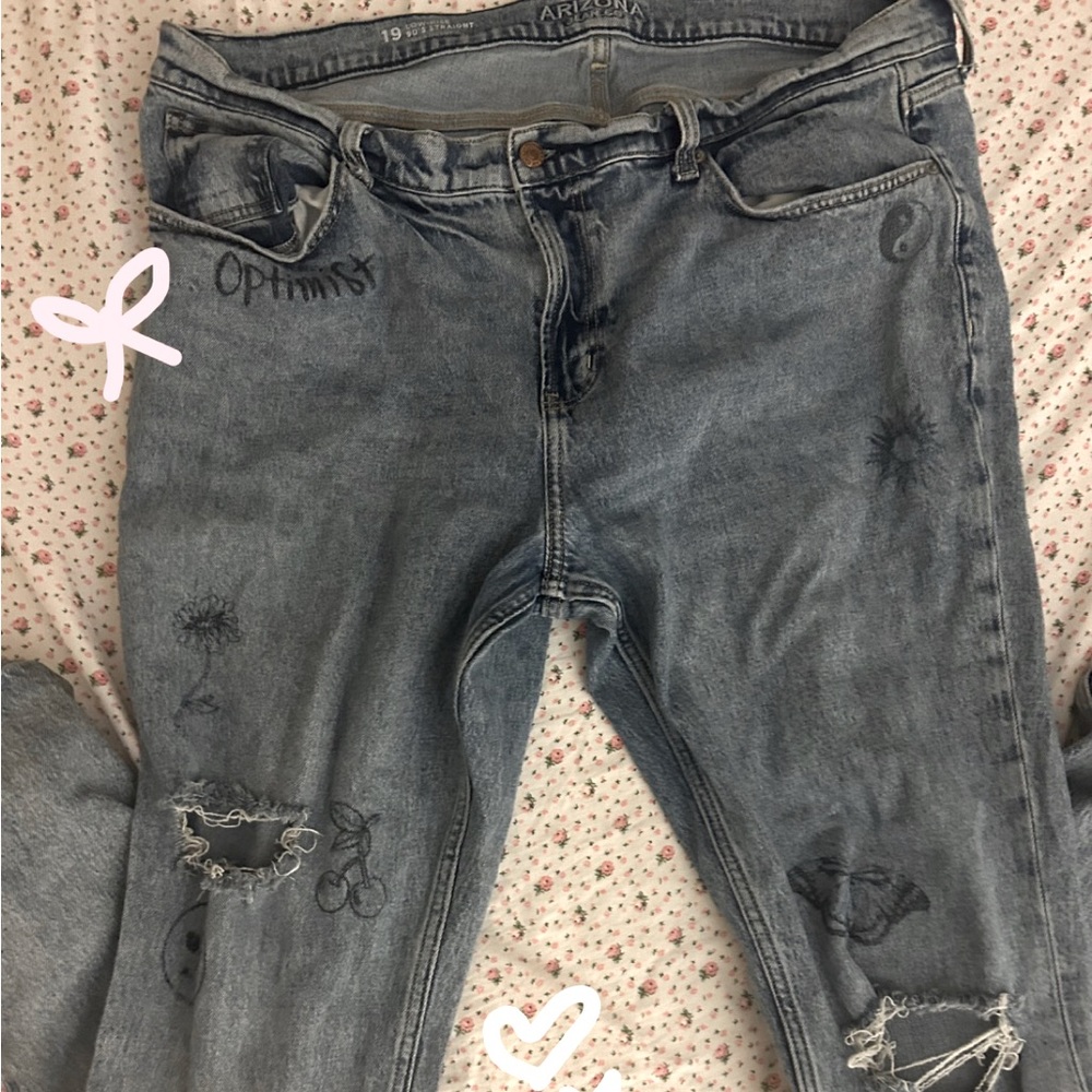 Light-blue ripped  jeans with drawing designs on it to give it that 90s look.